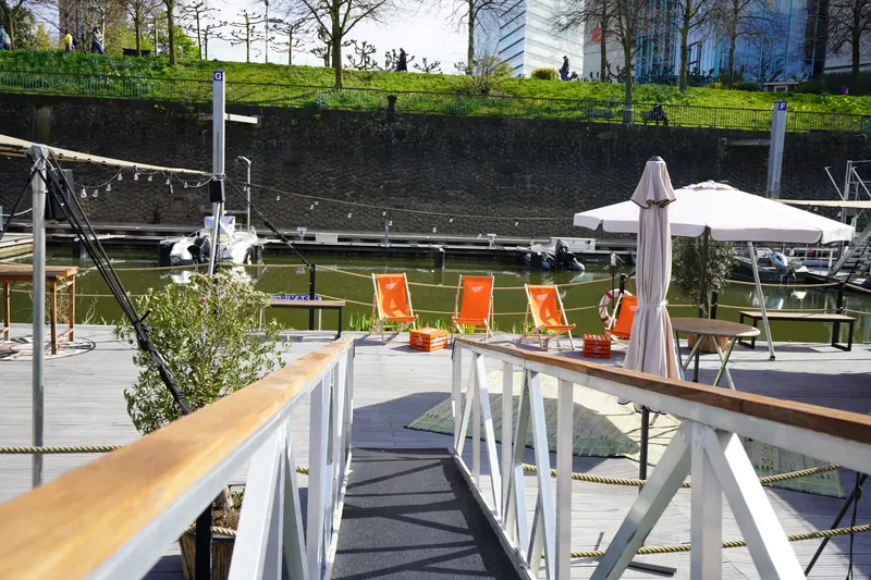 Sonnenterrasse des Harbor Club mit Liegestühlen und Blick auf die Marina Düsseldorf