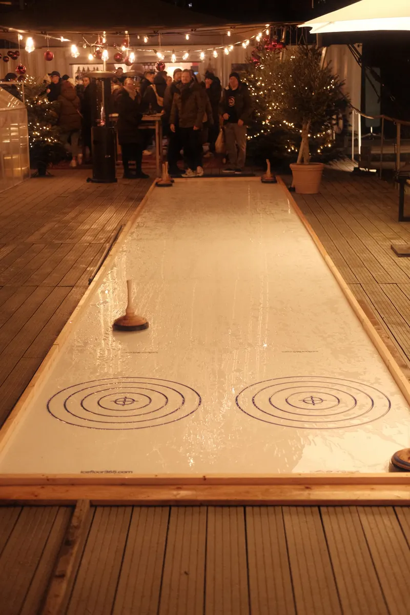 Eisstockbahn im Winter Club mit Lichterketten am Abend