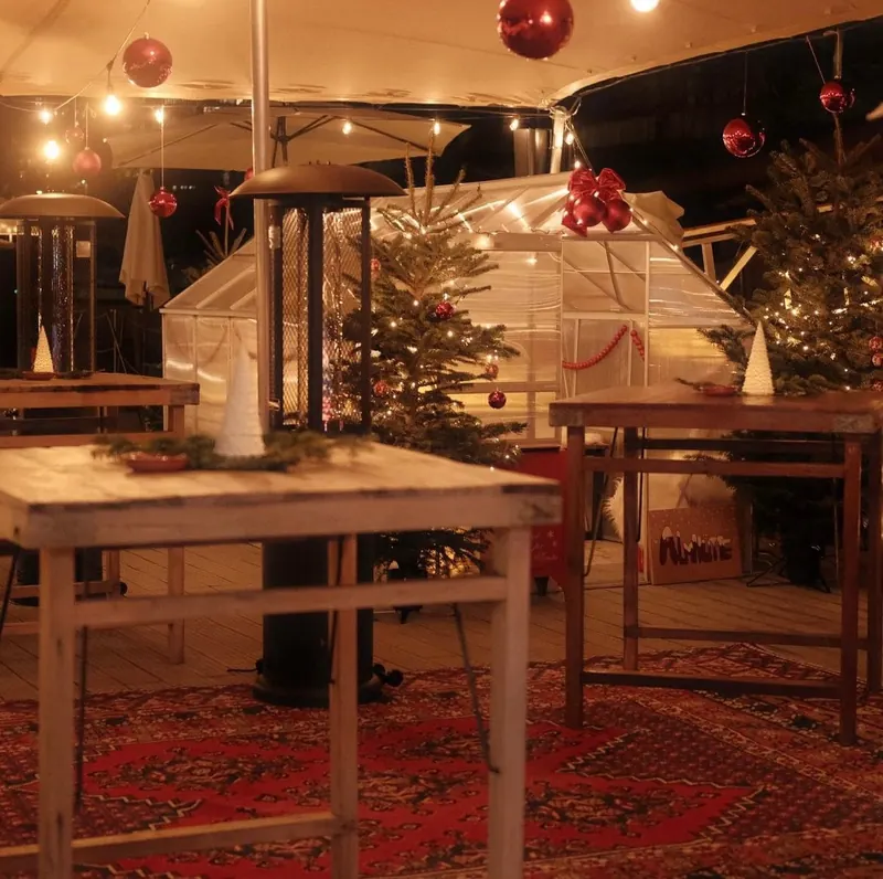 Gemütliche Holztische und Tannenbäume im Winter Club